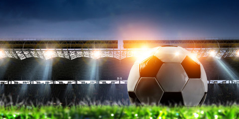 Full night football arena in lights with ball close up