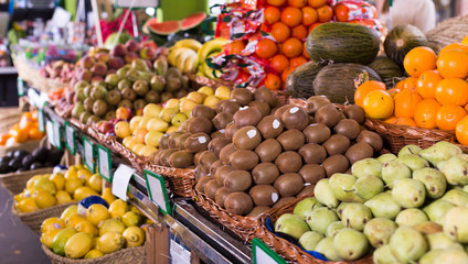 vegetables and fruits in wicker baskets on counter of greengrocery