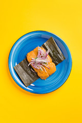 Peruvian Tamale, typical Peruvian breakfast. Made from corn and stuffed with chicken and served with purple onion salad.