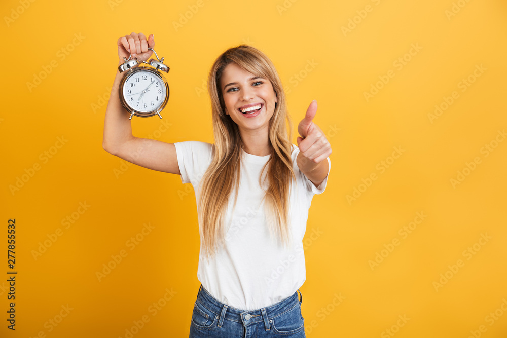 Canvas Prints happy smiling young blonde woman posing isolated over yellow wall background dressed in white casual