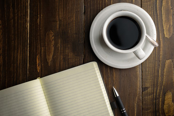 Black coffee and notebook on desk