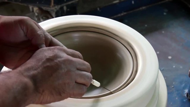 hands of a potter, creating an bowl using a terraja, Pottery polishing process with 2 hands in the final step. Before entering the kiln.