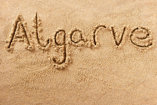 Algarve portugal word written in sand sign writing drawing drawn on a sunny summer beach holiday vacation travel destination message photo