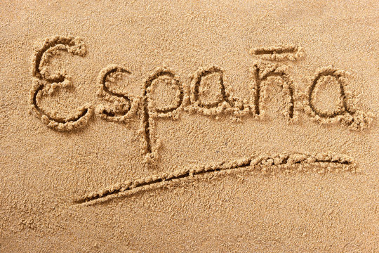 Espana spain word written in sand sign writing drawing drawn on a sunny spanish summer beach holiday vacation travel destination message photo