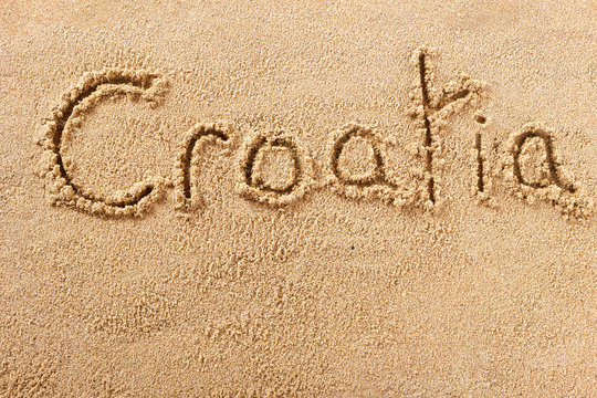 Croatia word written in sand sign writing drawing drawn on a sunny summer beach holiday vacation travel destination message photo