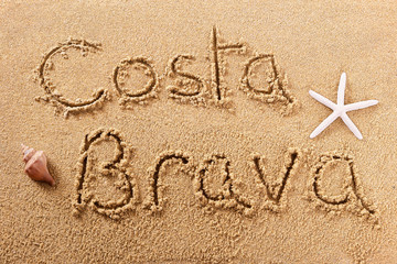 Costa Brava spain word written in sand sign writing drawing drawn on a sunny spanish summer beach with starfish holiday vacation travel destination message photo