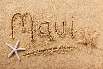 Maui word written in sand sign writing drawing drawn on a sunny hawaiian summer beach with starfish...