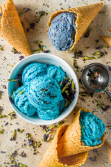 Fototapeta na wymiar Trendy Color Changing Ice Cream with blue flowers powder, Butterfly Pea Flower Blossom gelato with ice cream waffle cones
