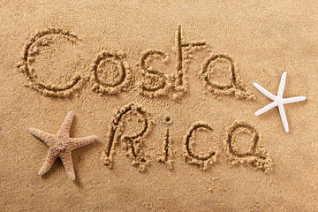 Fototapeta na wymiar Costa Rica word written in sand sign writing drawing drawn on a sunny summer beach with starfish holiday vacation travel destination message photo