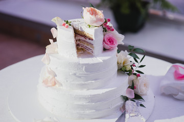 Obraz na płótnie Canvas Stylish modern wedding cake. Beautiful dessert decorated with fresh flowers and greenery.