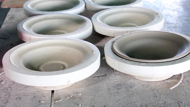 hands of a potter, creating an bowl using a terraja, Pottery polishing process with 2 hands in the final step. Before entering the kiln.