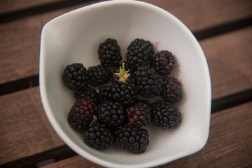 ripe blackberries in a white crockery bowl