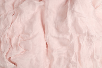 Soft smooth pink silk fabric background. Fabric texture.