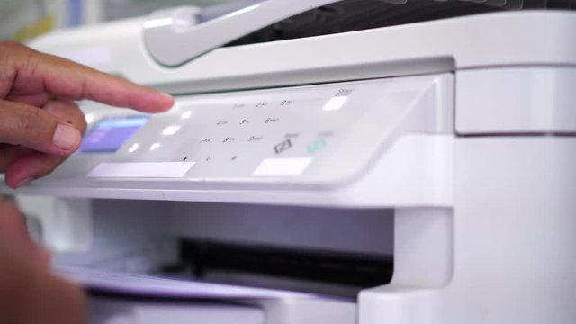 Documents printing concept : Business man hand pressing button machine supplies in control panel laser printer for copy scanner and printing document report graph chart in busy office 