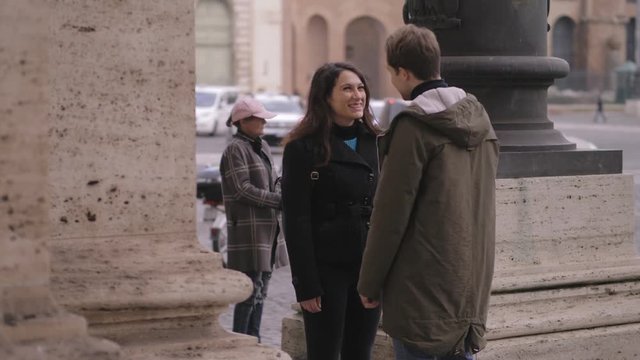 hidden woman observing her boyfriend kissing another woman in the street