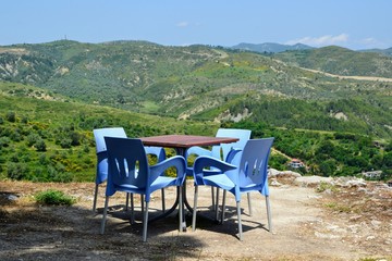 Table at the outdoor restaurant on the castle hillside slope. Place to rest and relax. Scenic view from the Berat Castle. Albania