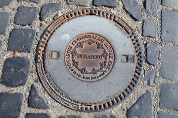 An iron manhole cover in a street of Budapest, Hungary
