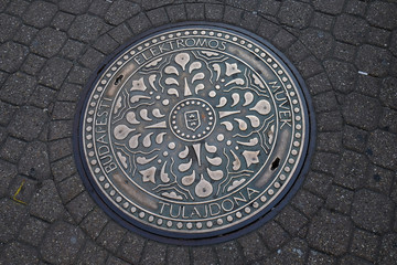 An iron manhole cover in a street of Budapest, Hungary