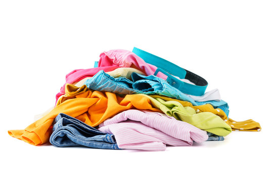 Messy pile of colorful summer clothes. White background.