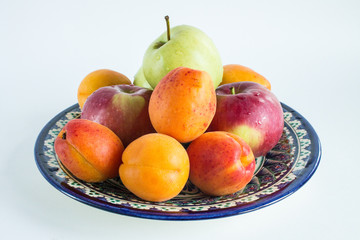 Fresh fruit on national Uzbek dishes with traditional ornament