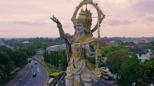 Aerial: Hindu statue on traffic island in Denpasar, Bali, Indonesia. 