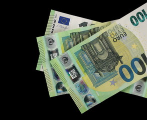 New hundred euro banknotes, bills isolated on black, top view