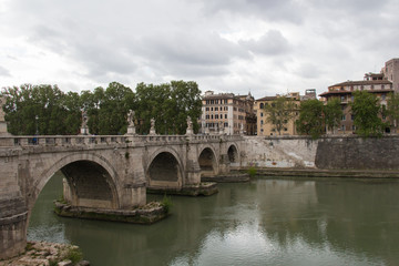 Fototapeta na wymiar Ponte Sant'Angelo or Aelian Bridge with rainy clouds on background, Rome, Lazio, Italy.