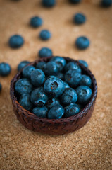 Freshly picked blueberries in woven natural screwpine leaf bowl. Juicy and fresh blueberries with on rustic table. Bilberry on wooden Background. Blueberry antioxidant. Concept for healthy eating.