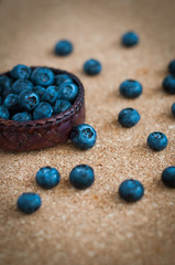 Freshly picked blueberries in woven natural screwpine leaf bowl. Juicy and fresh blueberries with on rustic table. Bilberry on wooden Background. Blueberry antioxidant. Concept for healthy eating.