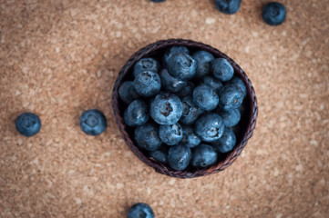 Freshly picked blueberries in woven natural screwpine leaf bowl. Juicy and fresh blueberries with on rustic table. Bilberry on wooden Background. Blueberry antioxidant. Concept for healthy eating.