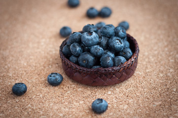 Freshly picked blueberries in woven natural screwpine leaf bowl. Juicy and fresh blueberries with on rustic table. Bilberry on wooden Background. Blueberry antioxidant. Concept for healthy eating.