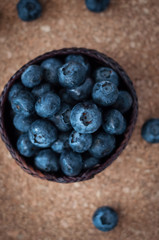 Freshly picked blueberries in woven natural screwpine leaf bowl. Juicy and fresh blueberries with on rustic table. Bilberry on wooden Background. Blueberry antioxidant. Concept for healthy eating.