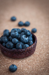 Freshly picked blueberries in woven natural screwpine leaf bowl. Juicy and fresh blueberries with on rustic table. Bilberry on wooden Background. Blueberry antioxidant. Concept for healthy eating.