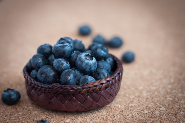 Freshly picked blueberries in woven natural screwpine leaf bowl. Juicy and fresh blueberries with on rustic table. Bilberry on wooden Background. Blueberry antioxidant. Concept for healthy eating.