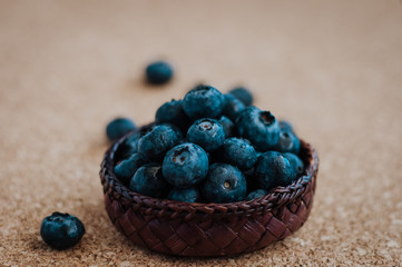 Freshly picked blueberries in woven natural screwpine leaf bowl. Juicy and fresh blueberries with on rustic table. Bilberry on wooden Background. Blueberry antioxidant. Concept for healthy eating.