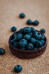 Freshly picked blueberries in woven natural screwpine leaf bowl. Juicy and fresh blueberries with on rustic table. Bilberry on wooden Background. Blueberry antioxidant. Concept for healthy eating.