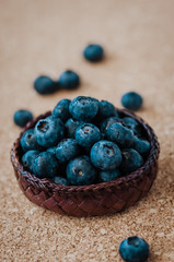 Freshly picked blueberries in woven natural screwpine leaf bowl. Juicy and fresh blueberries with on rustic table. Bilberry on wooden Background. Blueberry antioxidant. Concept for healthy eating.