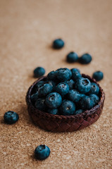 Freshly picked blueberries in woven natural screwpine leaf bowl. Juicy and fresh blueberries with on rustic table. Bilberry on wooden Background. Blueberry antioxidant. Concept for healthy eating.