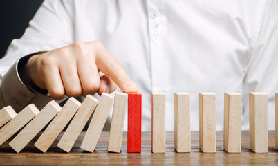 Businessman stops domino falling. Risk management concept. Successful strong business and problem...