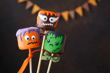 Halloween cake pops and chocolate marshmallow with funny faces.