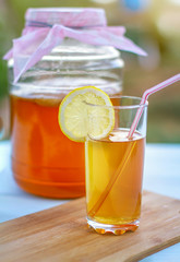 Glass jar with Kombucha, poured glass with Kombucha and raspberries in the summer garden.