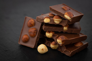 milk chocolate pieces with nuts on a dark background