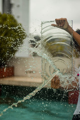 A guy is trying to protect him from the water splash by a glass shield