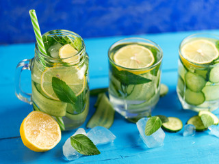 Detox wall-mounted cucumber water with lemon and mint on a wooden blue table