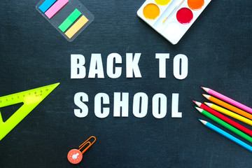 Fototapeta na wymiar School supplies on blackboard background. Back to school concept