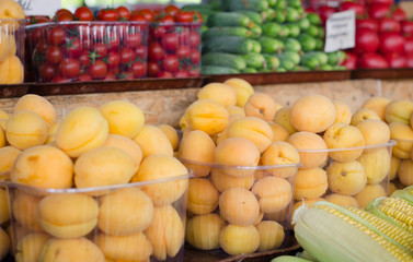 Containers with different ripe berries and fruit at market