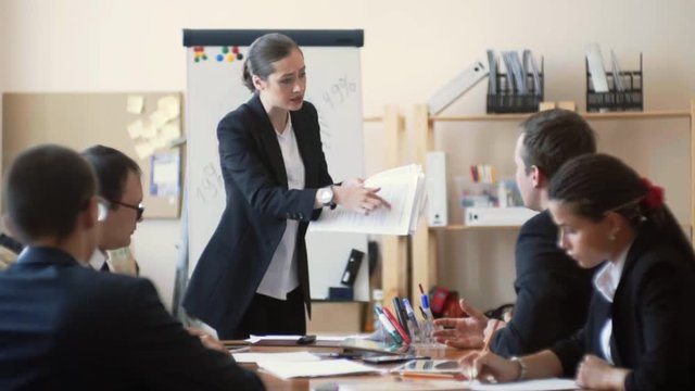 the businesswoman is very dissatisfied with the work of her employees, she returns them the papers and loudly reprimands