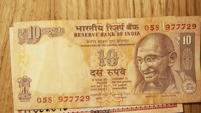 Laying Down Asian Currency on the Table. Rupees from Nepal.