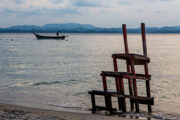 playa con escalera y barca al fondo al atardecer en Malasia. Belleza y tranquilidad, Vacaciones