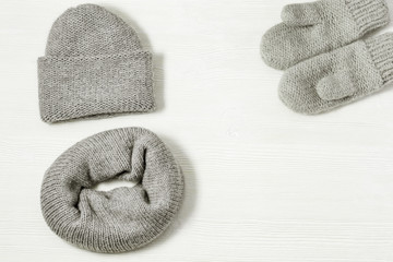 Flat lay from warm winter women's clothing, knitted mittens, knitted hat, knitted scarf. Winter woolen clothes. Top view. Copy space.